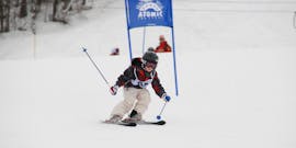 Ein Kind fährt Slalom während dem Kinder-Skikurs “Kids Club” (4-16 J.) für Fortgeschrittene mit Skischule Ski Total Kirchdorf.