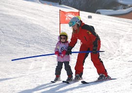 Ein Kind lernt mit dem Skilehrer das Skifahren beim Privaten Kinder-Skikurs für Anfänger mit Skischule Ski Total Kirchdorf.