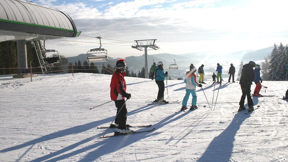 Tijdens de Skilessen voor Tieners (13-17 j.) - Alle niveaus - Halve Dag, geniet een groep tieners van het skiën onder leiding van een ervaren skileraar van de Skischule Snow & Bike Factory Willingen.