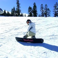 Unter der Aufsicht eines Lehrers der Skischule Snow & Bike Factory Willingen fährt ein Junge im Rahmen des Angebots Snowboardkurs für Kinder (7-12 J.) - Ganztags die Pisten hinunter.