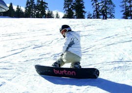 Unter der Aufsicht eines Lehrers der Skischule Snow & Bike Factory Willingen fährt ein Junge im Rahmen des Angebots Snowboardkurs für Kinder (7-12 J.) - Ganztags die Pisten hinunter.