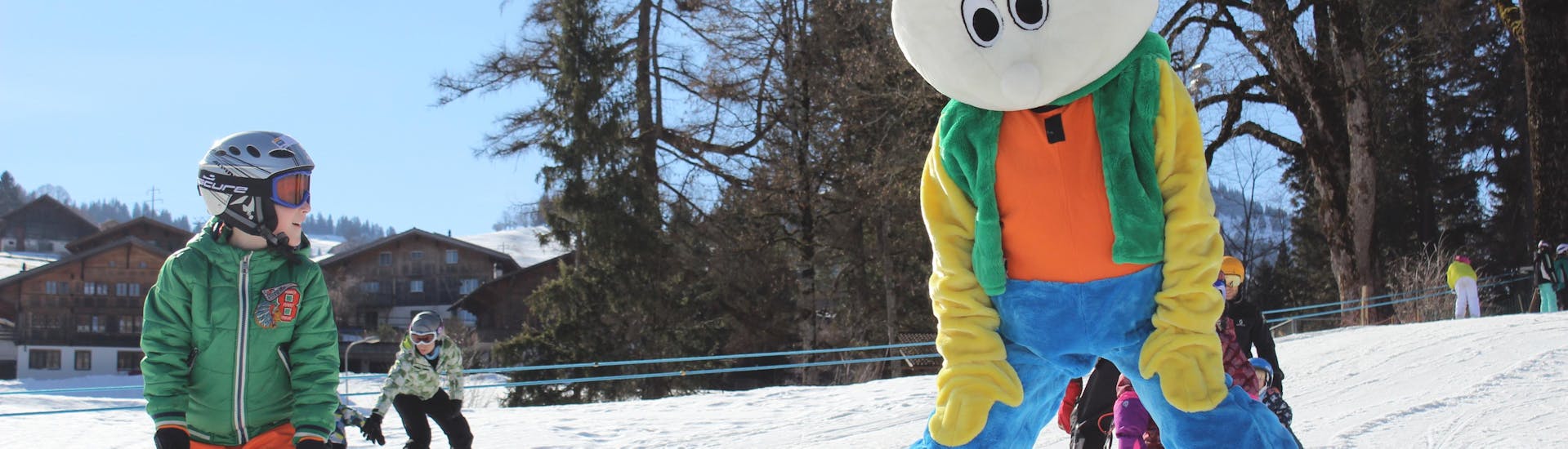 The mascot of Swiss Ski School Zweisimmen helps little children to learn how to ski in plough.