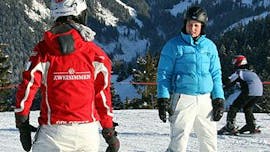 Un istruttore insegna a uno studente durante le lezioni di sci per adulti di tutti i livelli della scuola svizzera di sci Zweisimmen.