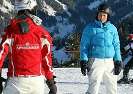 Ein Lehrer unterrichtet einen Schüler beim Skikurs für Erwachsene für alle Levels mit Schweizer Skischule Zweisimmen.