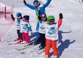Eine Gruppe Kinder hat mit ihrem Skilehrer der Skischule Silvaplana Top Snowsports während ihrem Kinder-Skikurs für alle Levels Spaß im Schnee.