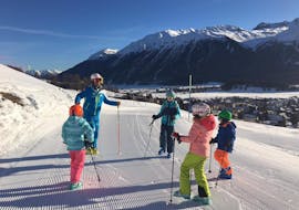 A group of teenagers wait on the slopes during their ski course for young people for all levels with the Silvaplana Top Snowsports ski school. 