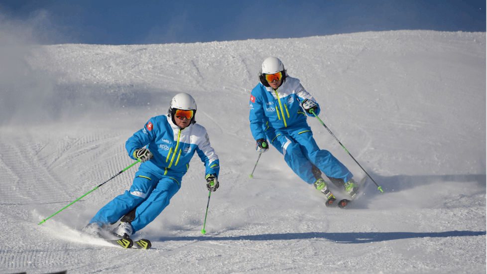 Two skiers ski down the slope during the private kids ski lessons with the Silvaplana Top Snowsports ski school.