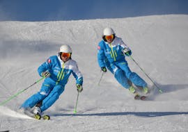 Twee skiërs skiën de piste af tijdens de privé skilessen voor kinderen bij skischool Silvaplana Top Snowsports.