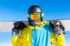 Een snowboarder kijkt in de camera tijdens zijn privé snowboardlessen voor kinderen en volwassenen voor alle niveaus bij de Silvaplana Top Snowsports skischool.