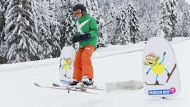 Een kind skiet de piste af tijdens de skilessen voor kinderen voor gevorderden bij skischool Dachstein West in Gosau.