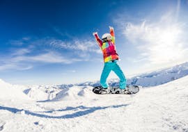 Ein Kind springt beim Snowboardunterricht für Fortgeschrittene mit der Skischule Dachstein West in Gosau in die Luft.