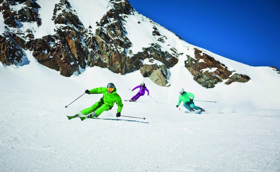 Drie skiërs rijden van een piste af tijdens hun privé skilessen voor volwassenen van alle niveaus bij skischool Dachstein West in Gosau.