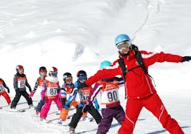 A group of children skiing during their kids ski lessons for advanced skiers with skischule Heugenhause Saalbach in Hinterglemm. 