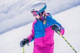 During the Kids Ski Lessons (4-13 years) - All Levels, a young girl is taking the first steps on skis under the supervision of an experienced ski instructor from WIWA | DSV Skischule & Skiverleih.