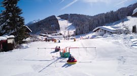 The children play together in the beautiful Kinderland in the snow during the kids ski lessons "BOBOs Kinderclub" (4-14 years) - beginner of the Ski School Fieberbrunn Widmann Mountain Sports.
