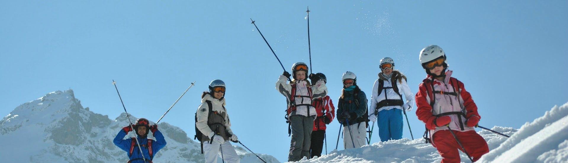 Eine Gruppe Kinder lächelt in die Kamera während sie beim Kinder Skikurs "BOBO Kinderclub" (4-14 Jahre) - Anfänger mit der Skischule Fieberbrunn Widmann Mountain Sports eine kurze Pause einlegen.