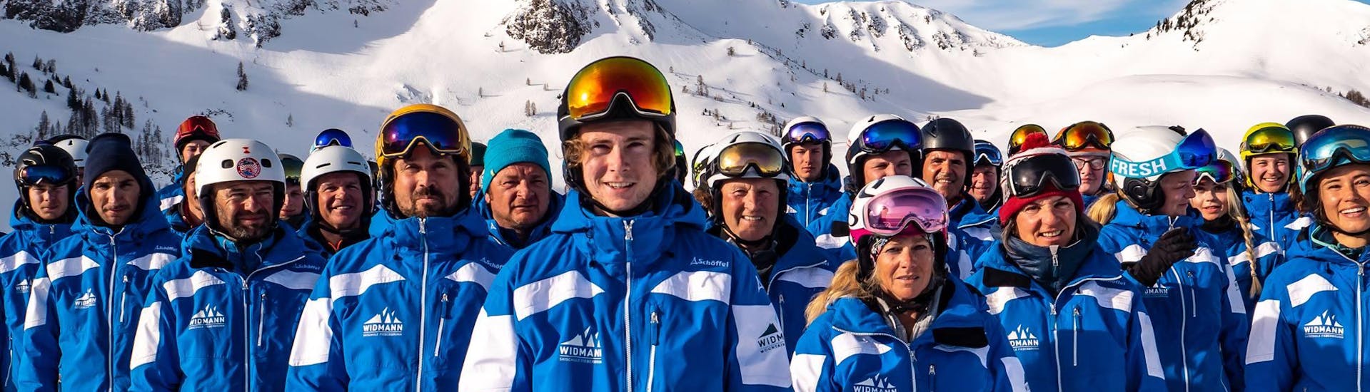 Die Skilehrer der Skischule Fieberbrunn Widmann Mountain Sports die unter anderem auch das Angebot Privater Skikurs für Erwachsene - Alle Levels unterrichten, posieren gemeinsam für ein Gruppenfoto.