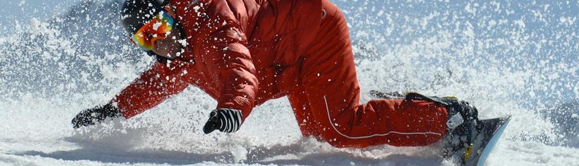 Uno snowboarder padroneggia le sue curve frontside e backside durante le lezioni private di snowboard - per tutti i livelli e le età, organizzate da un team di ESF Val d'Isère.