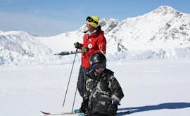 Un giovane sciatore impara a sciare con l'aiuto del suo maestro della scuola di sci Red Carpet Champéry durante le lezioni private di sci per bambini (3-9 anni) - Tutti i livelli.
