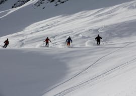 Three skiers skiing during their adult ski lessons for advanced skiers with ski school Warth in Warth-Schröcken.