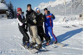 Vier snowboarders tijdens hun snowboardlessen voor kinderen & volwassenen (vanaf 10 j.) - gevorderden bij skischool Wilder Kaiser in St. Johann.