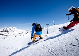 Ein Snowboarder rutscht den Berg hinunter während eines Snowboardkurses für Kinder und Erwachsene für alle Niveaus mit der Skischule Warth in Warth-Schröcken.