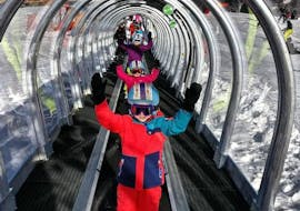 De jeunes skieurs utilisent avec joie le tapis magique de l'école de ski ESI Easy2Ride Morzine pendant leur Cours de ski pour Enfants (5-13 ans) - Après-midi - Débutant.
