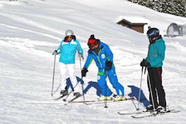 Ein Skilehrer überprüft die Grundlagen der Skitechnik mit seinen Schülern während einer privaten Skistunde für Erwachsene im ESI Pro Skiing in Châtel.