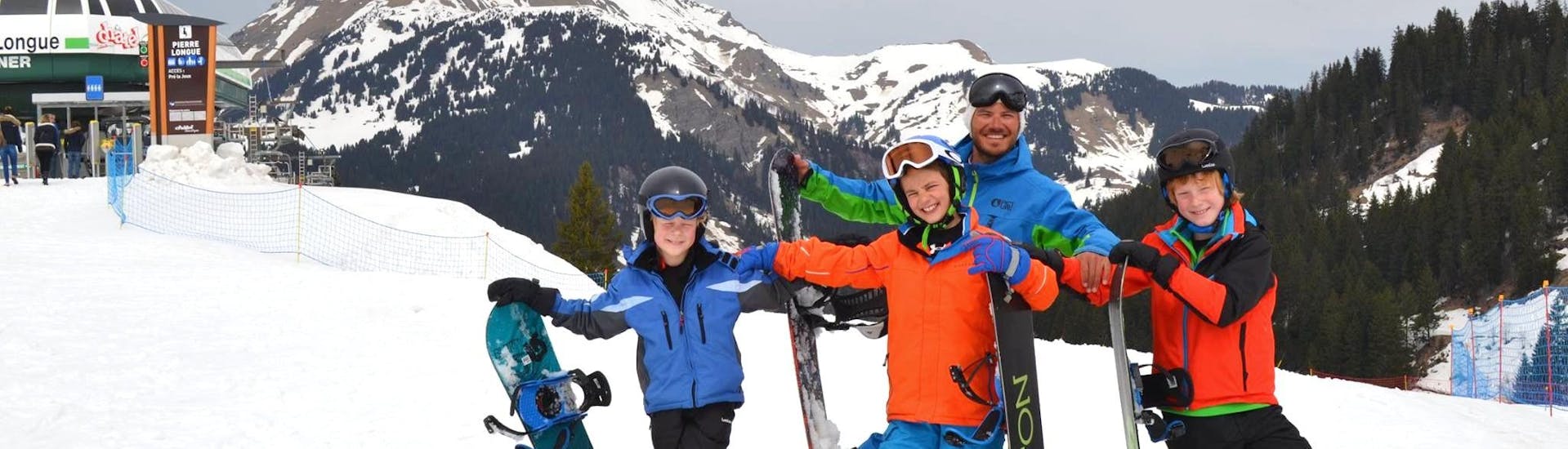 Des snowboardeurs prennent une pause bien méritée sur les pistes de Châtel après un cours de snowboard (dès 10 ans) avec l'ESI Pro Skiing Châtel.
