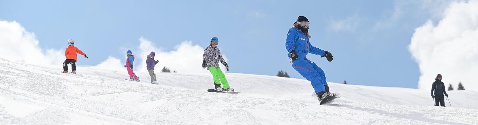 Des personnes prennent des Cours de snowboard (dès 8 ans) pour Tous niveaux avec notre partenaire Starski Grand Bornand.