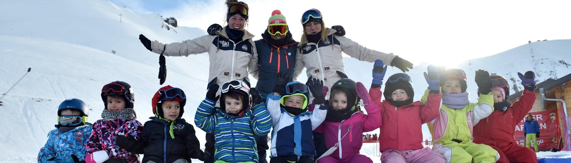 Des enfants sont assis en compagnie de leur moniteurs de ski de l'école de ski ESI Valfréjus dans le jardin d'enfants pendant leur Cours de ski pour Enfants "Jardin d'enfants" (3-5 ans).
