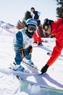 Image d'un petit enfant avec son moniteur Neige Aventure pendant un Cours de ski Enfants "Mini Kids" (3-5 ans).