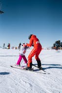 A Neige Aventure instructor teaches a young child how to ski.