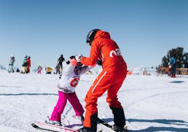 A Neige Aventure instructor teaches a young child how to ski.