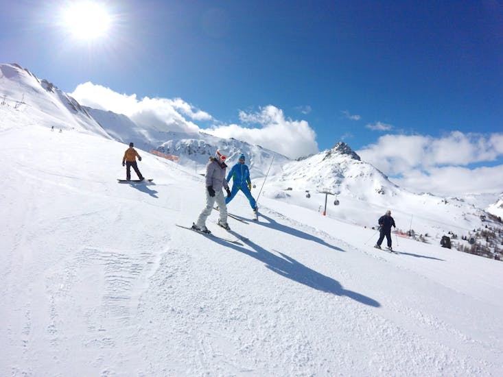 Een skiër leert skiën dankzij de hulp van haar skileraar van de skischool ESI Valfréjus tijdens haar privélessen voor volwassenen - alle niveaus.