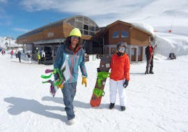 Een snowboarder en hun snowboardleraar van de skischool ESI Valfréjus staan ​​bovenaan de skilift klaar om hun Privé Snowboardlessen - Alle Niveaus en Leeftijden te beginnen.