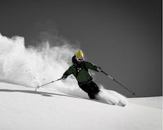 A skier skies down the off-piste slope in beautiful powder snow during the off-piste skiing lessons for teens and adults - all levels of the ski school Motion Center Lofer.