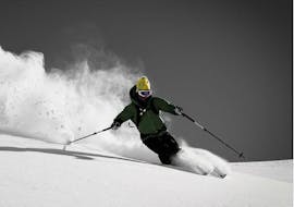 A skier skies down the off-piste slope in beautiful powder snow during the off-piste skiing lessons for teens and adults - all levels of the ski school Motion Center Lofer.