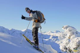 A skier happily climbs the mountain and smiles proudly into the camera with the private and groups ski touring guide Kitzbühel - All Ages of the ski school Motion Center Lofer.