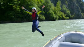 A girl is jumping into the refreshing water of the Inn river during the Rafting in the Imster Schlucht - Girlspower with CanKick Ötztal.
