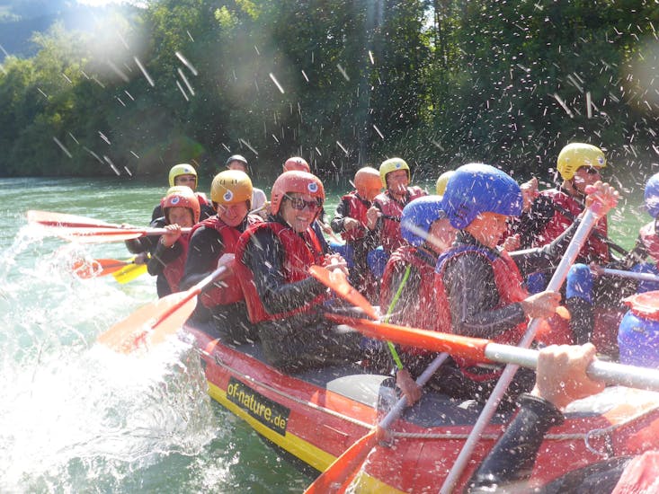 Eine Gruppe an Teilnehmern auf dem Raftin boot auf dem Iller Fluss mit Spirits of Nature Allgäu.