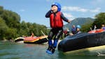 Kind springt in de rivier vanaf de raftingboot tijdens een raftingtour op de rivier de Iller in Allgäu met Spirits of Nature Allgäu.