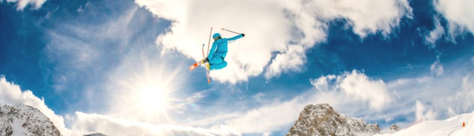 Een skiër maakt een grote sprong tijdens een privé freestyle skiles voor gevorderde skiërs met ESI First Tracks in Courchevel.