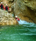A woman sliding down into a natural pool on her Outdoor-Combi Rafting & Canyoning with the local guides from Adventure Club Kaiserwinkl. 