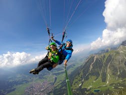 De monitor en een deelnemer genieten van hun tijd in de lucht tijdens het tandemparagliden vanaf de Nebelhorn in Oberstdorf met Himmelsritt Oberstdorf.