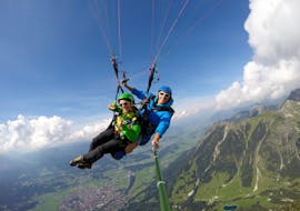 De monitor en een deelnemer genieten van hun tijd in de lucht tijdens het tandemparagliden vanaf de Nebelhorn in Oberstdorf met Himmelsritt Oberstdorf.