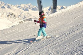 A kid having fun during its Private Ski Lessons for Kids - High Season - Arc 2000 with Evolution 2 - Arc 2000.