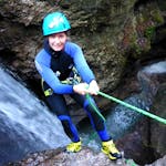 Een vrouw abseilt van een waterval tijdens haar Canyoning Tour "Narrow Aquasplash" in Taxaklamm onder leiding van het ervaren team van CIA Canyoning in Austria & more Adventures.