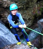 A woman abseiling down a waterfall at her Canyoning Tour "Narrow Aquasplash" at Taxaklamm under the instruction of the experienced team of CIA Canyoning in Austria & more Adventures.