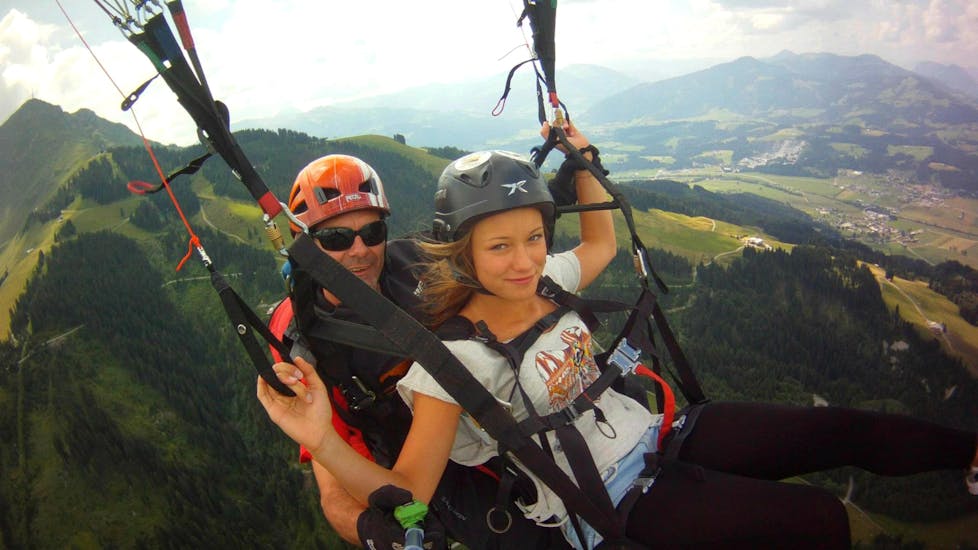 A customer and her guide during Tandem Paragliding in Fieberbrunn from Wildseeloder with Mountain High Adventure Center Tirol. 